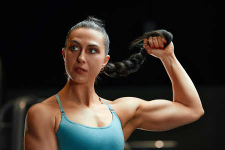 Classic bodybuilding. Muscular fitness woman doing exercises in the gym. Fitness woman in the gym. Bodybuilder woman in the gym.の写真素材