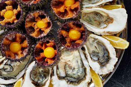 Top view of seafood platter: shellfish, oysters, sea urchin and balsamic sauce