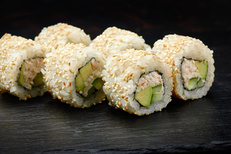 Traditional delicious fresh sushi roll set on a black background. Sushi roll with rice, cream cheese, avocado, salmon, sesame. Philadelphia. Sushi menu. Japanese kitchen, restaurant.の写真素材