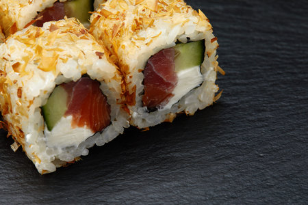 Traditional delicious fresh sushi roll set on a black background. Sushi roll with rice, cream...