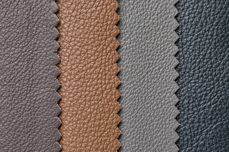 Samples of beige, brown, gray black leather. Leather crafts and craftwork. View from above.