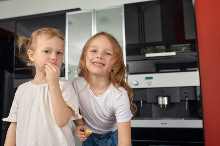 Two little girls siblings having fun and eating on the kitchen at home with japanese food.