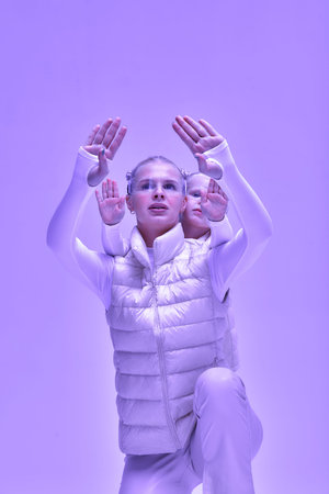 A young woman with her little daughter in a white high-tech clothes wearing smart glasses and...