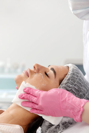 Woman having cleaning facial treatment in spa
