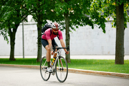 Caucasian handsome young man in protective helmet goes out for bicycle ride through city streets on...