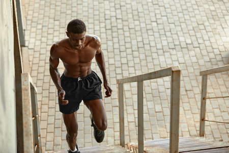 Sport Motivation. Black Male Athlete Running Up On Urban Stairs Outdoors, Enjoying Morning Workout, With Free Spaceの写真素材