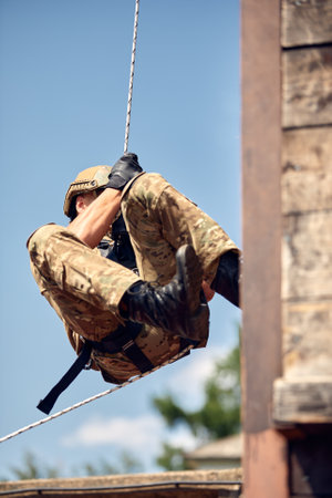 Soldier training rappel with rope. Military man does hanging on climbing equipmentの写真素材