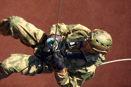 Special forces fighter descends from a skyscraper to storm the apartment. Police, counter terrorism concept. Mixed mediaの写真素材