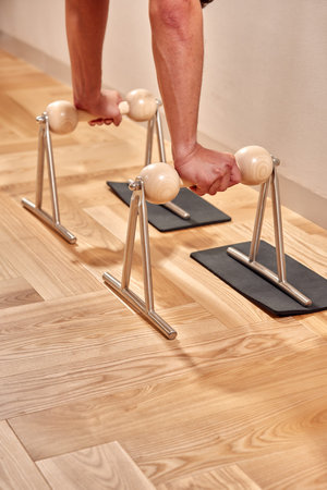 Fit man doing a lunge stretch yoga pilates exercise to strengthen and tone his muscles using a...