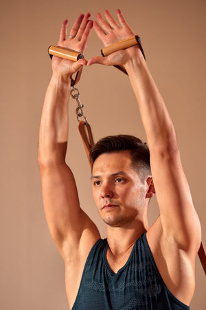 Pilates reformer workout exercises man at gym indoor.
