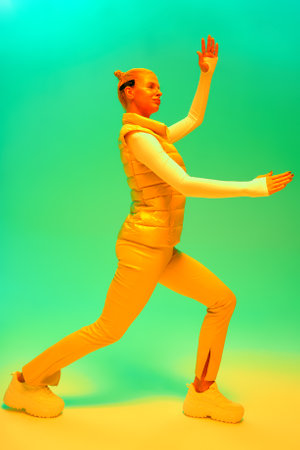 Woman in futuristic costume. Female in modern VR glasses interacting with network while having virtual reality experience. Augmented reality game, future technology, AI concept. VR. Neon green light.の写真素材