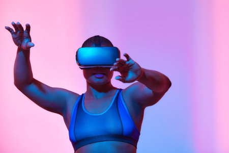 African american woman streamer playing video game using virtual reality glasses at gaming roomの写真素材