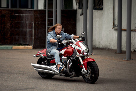 Biker rides a motorcycle in an urban landscape.