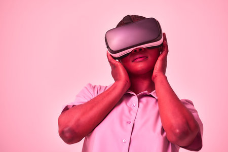 Young african american positive woman in black virtual reality glasses with vr headset posing,...