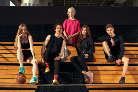 A friendly company of guys and girls are having fun on the basketball court, they are going to play basketball.の写真素材