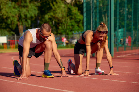 Start of the race of man and woman at the stadium, track and field athletics running, diversity joint training of men and women.の写真素材