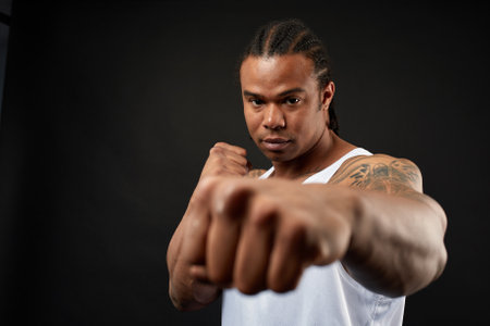 portrait of African-American athlete man boxing on black backgroundの写真素材