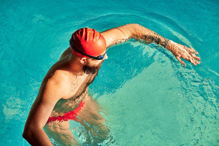 swimmer standing on diving board ready to jump into competition swimming poolの写真素材