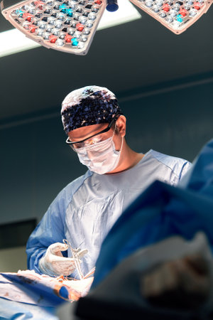 Group of surgeons doing surgery in hospital operating theater. Medical team doing critical operation.の写真素材