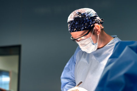 Surgeon close-up in hard work in the operating room. Surgeon in operating room with surgical equipment. Modern equipment in the operating room. Medical education.の写真素材