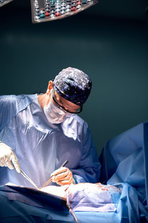 Surgeon close-up in hard work in the operating room. Surgeon in operating room with surgical...