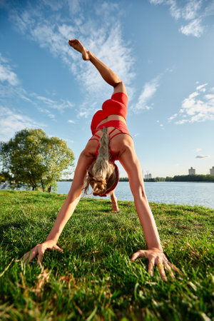 Young woman doing innovative animal flow movement outdoors, training animal flow at sunsetの写真素材