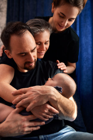 Woman and man holding a newborn. Mom, dad and baby. Close-up. Portrait of young smiling family with...