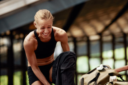 Young athlete girl getting ready for a workout at the stadium. Attractive slender blonde in a black...