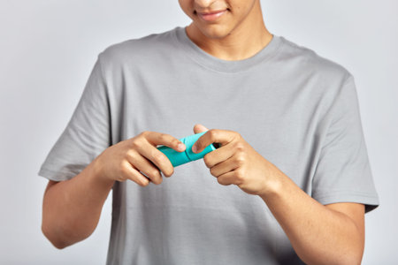 Happy smiling guy opening facial wash bottle, preparing to apply the beauty product on his face....