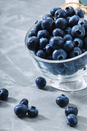 Blueberry gray background. Close-up, ripe blueberry berries on a gray background ecological packaging. Delivery of products, copies of space, photos for the catalog of stores.の写真素材