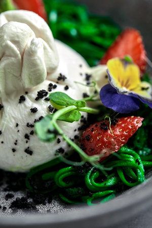 Burrata salad with strawberries and seaweed, on a gray background. Salad with buratta cheese on a gray plate and concrete marble background. close-upの写真素材