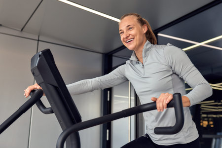 Woman enjoying a workout on a stationary bike in a modern gym