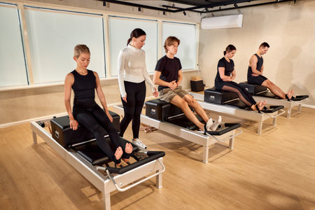 Group fitness session with reformer Pilates equipment at a modern studio