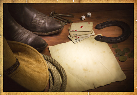 American west background with poker cards and cowboy clothes.Old paper for designの写真素材