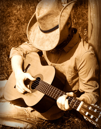 Cowboy  plays guitar on ranch .Country musicの写真素材