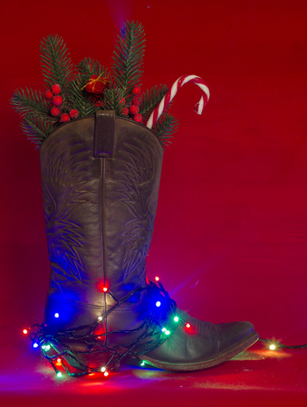 American West traditional cowboy boot on christmas red background for textの写真素材