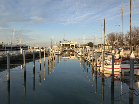 Wooden pilings for boats and moored boats at the dockのeditorial素材