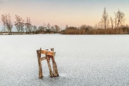 broken bridge in a frozen lakeの写真素材