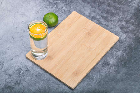 Cut a piece of green tangerine into a glass of waterの写真素材