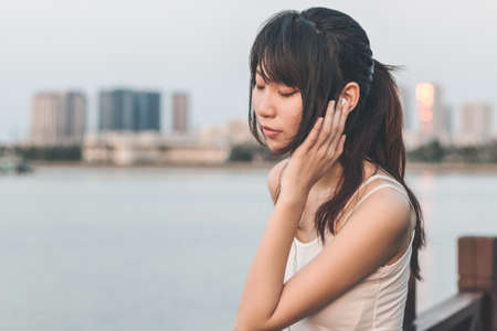 Girl listening to music by the seaの写真素材
