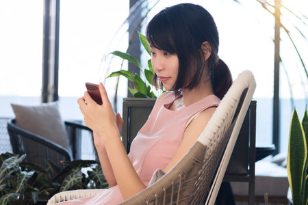 Girl sitting in a chair and playing with a mobile phone