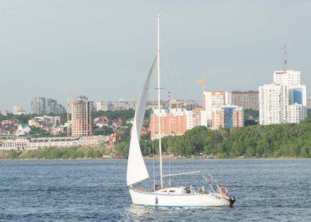 sailing ship floats on the river and the city in the backgroundの写真素材