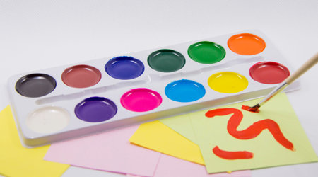 palette of color, paper and brush on white background