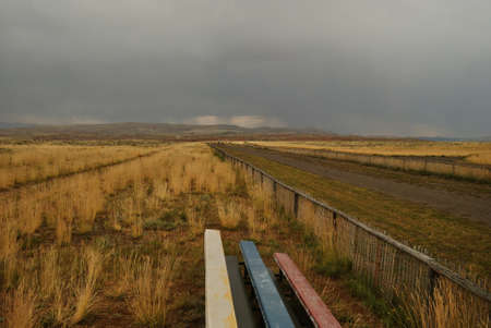 nature landscape of benches and fields and fence inwyoming, usaの写真素材