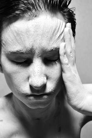 portrait photo of white mud face skrewed up in pain.black and whiteの写真素材