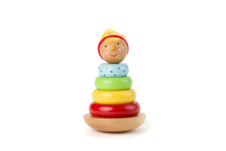 Pyramid build from colored wooden rings with a king head on top. Toy for babies and toddlers to joyfully learn mechanical skills and colors. Studio shot on white background.の写真素材