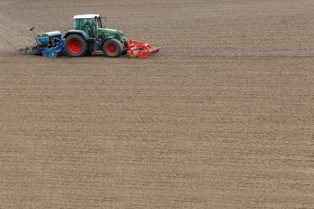Farmer seeding crops at field in springの写真素材