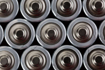 Close up top view on blurred rows of AA batteries energy abstract background of batteries. Shallow depth of field.の写真素材
