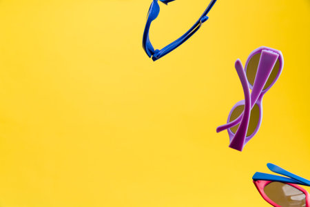 Color Children sunglasses isolated on yellow background. Concept of sun protection summer and...