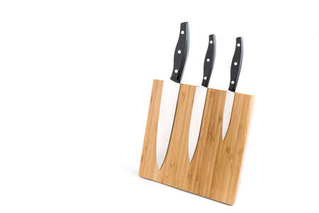 Wooden knife holder with three different types of knifes on white background. Studio shot,の写真素材